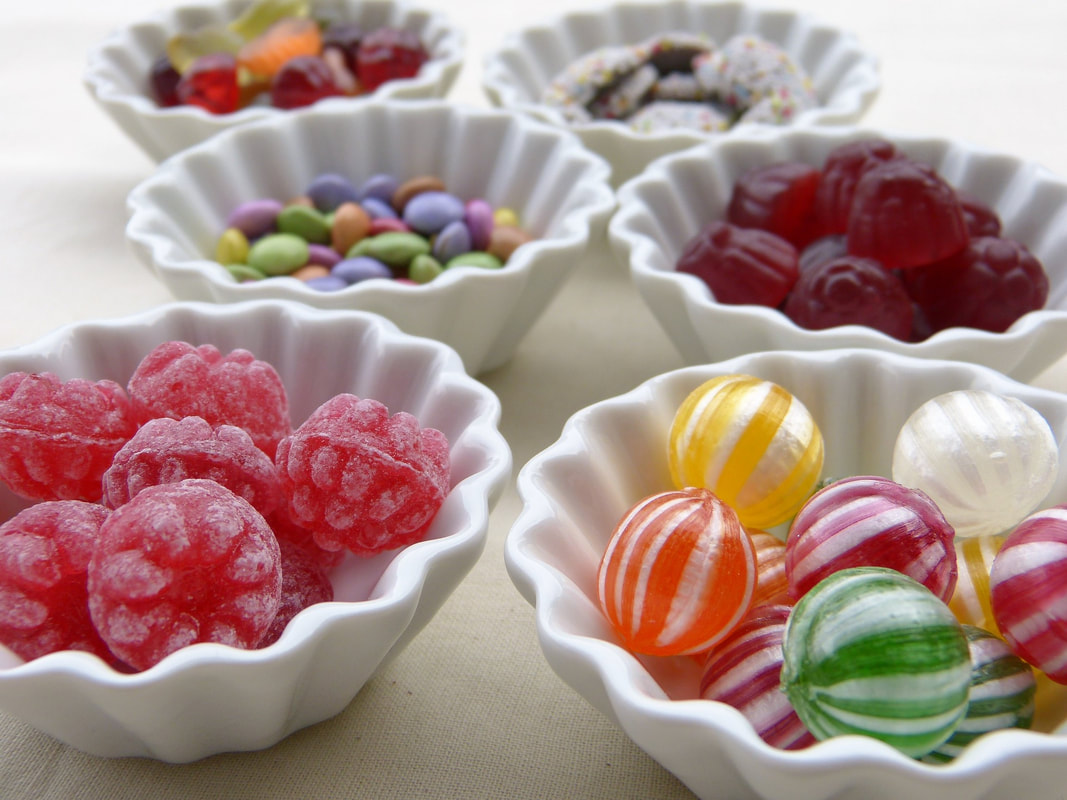 bowls of colored candy in white bowls